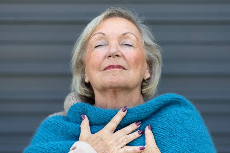 an older woman taking a deep, clear breath