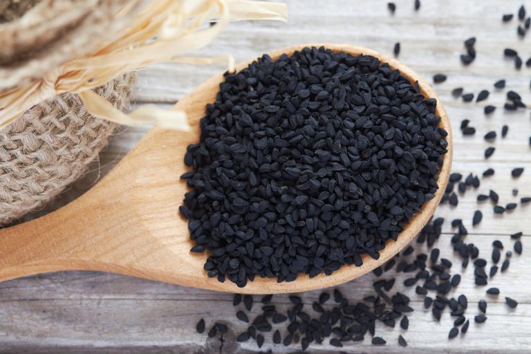 Black cumin seeds in a wooden spoon
