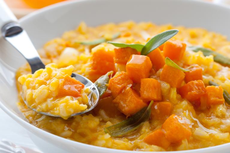 a bowl of risotto with chopped pumpkin on top